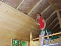 A customer installing the finished ceiling of a cabin kit built by bavariancottages.com and shipped to New York State